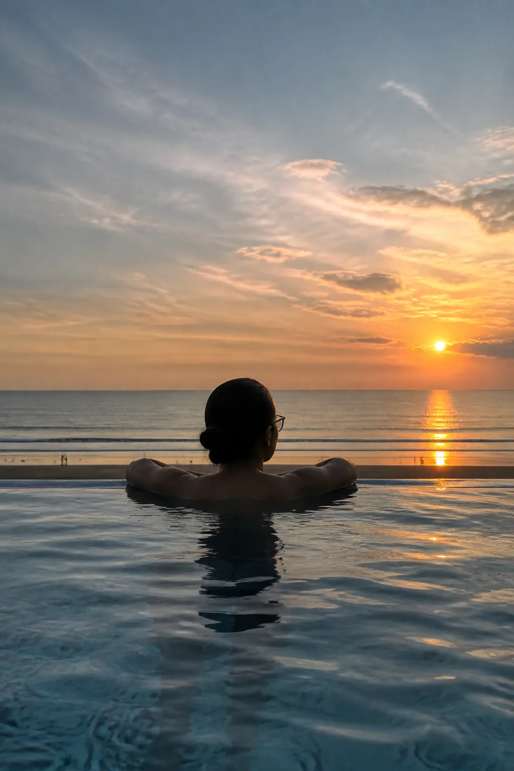 海へ沈む夕日をプールから眺める大西ライさん